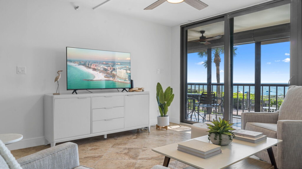 real estate photography of a living room with tv and beach