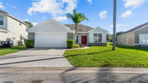 high res image of the front of a house with red door in davenport with palm tree.